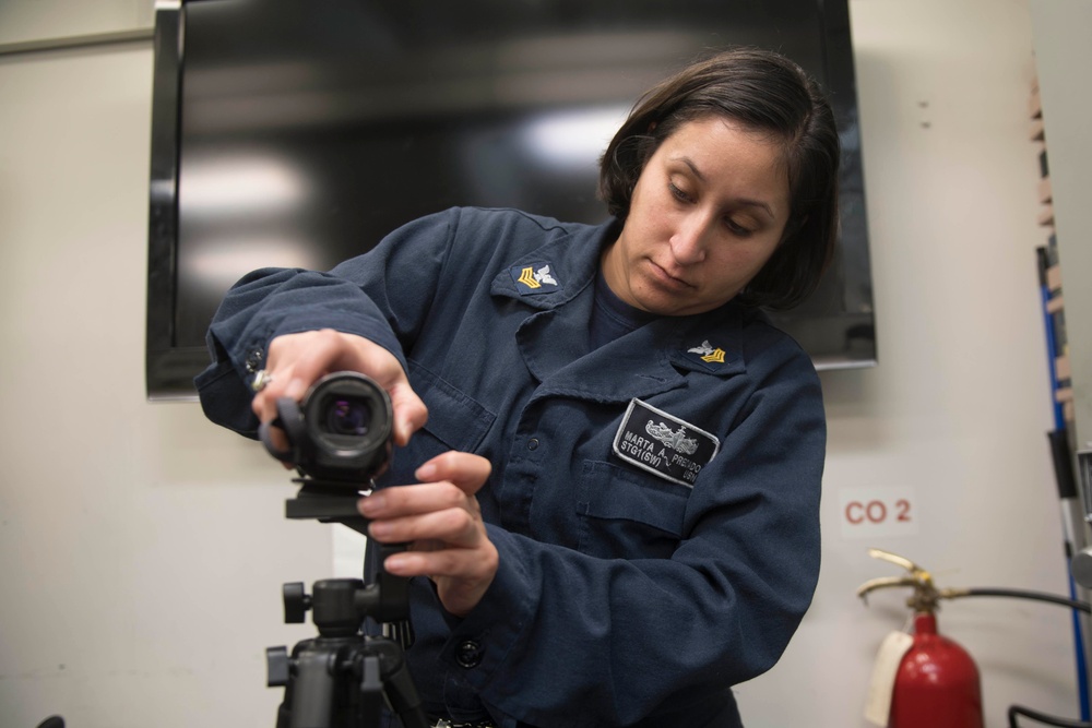 Sonar Technician (Surface) 1st Class Marta Perciado sets up a video camera for Sailors to record themselves reading books to send home to their families.