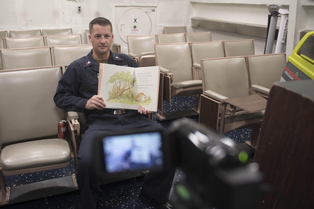 Navy Counselor 1st Class Andrew Eichman records himself reading a book to his daughter through the United Through Reading program aboard USS Spruance (DDG 111).