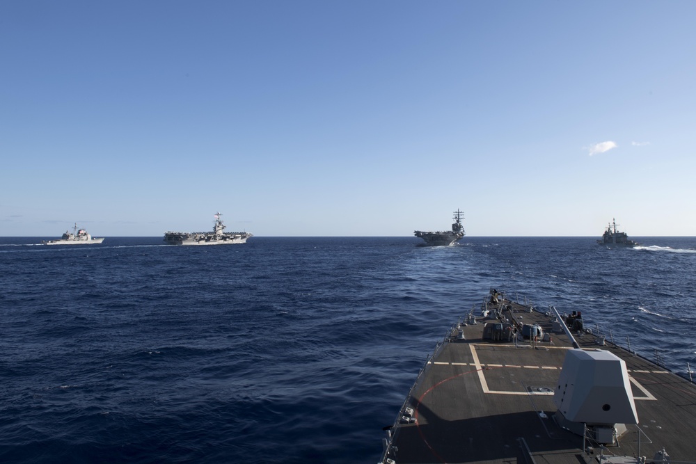 USS Spruance (DDG 111) cuts through the Philippine Sea in formation with USS Mobile Bay (CG 53), left, USS John C. Stennis (CVN 74) and USS Ronald Reagan (CVN 76), and USS Chancellorsville (CG 62), right.