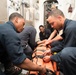 Ship’s Serviceman Seaman Apprentice Logan Parker, left, and Quartermaster Seaman Jordan Hall strap a simulated wounded Sailor into a stretcher during a medical training exercise aboard USS Chung-Hoon (DDG 93).