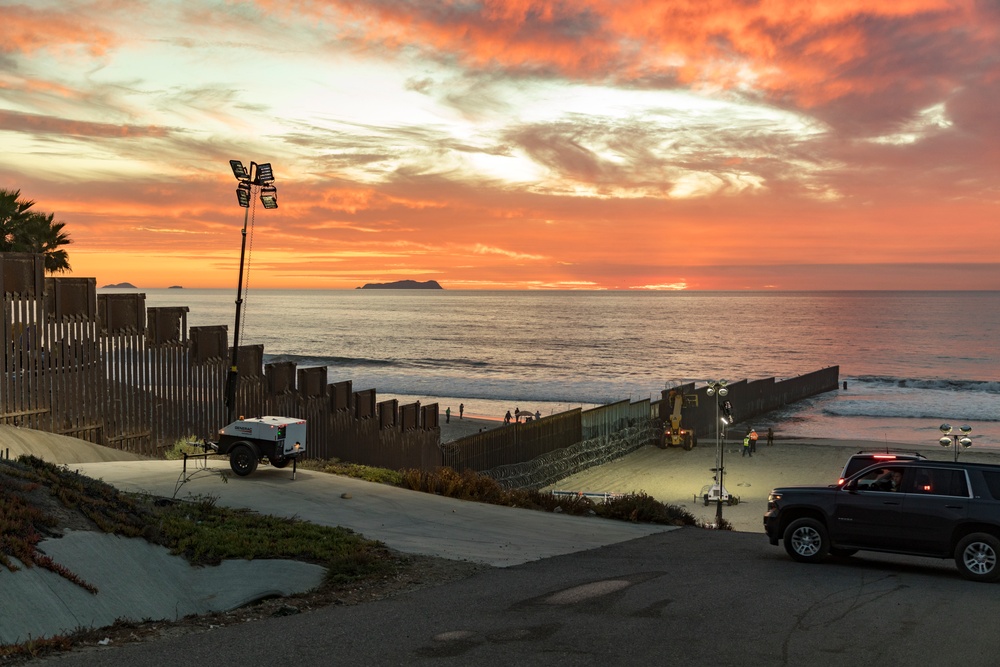 U.S. Border Patrol stands watch during border fence reinforcement