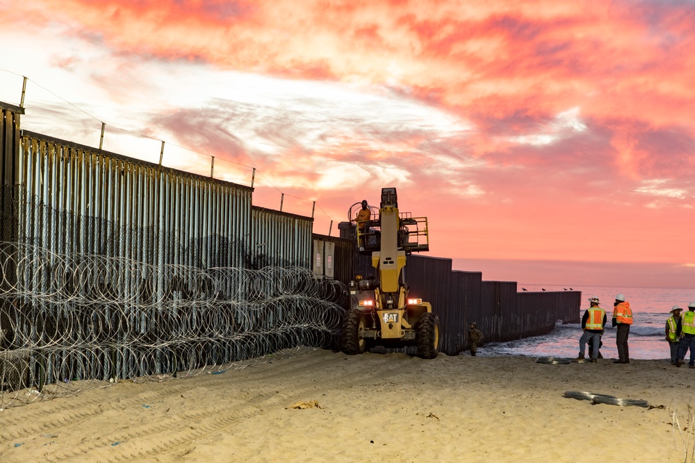 U.S. Border Patrol stands watch during border fence reinforcement