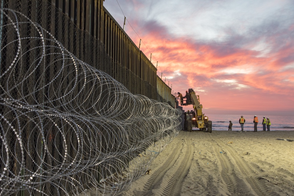 U.S. Border Patrol stands watch during border fence reinforcement