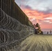 U.S. Border Patrol stands watch during border fence reinforcement