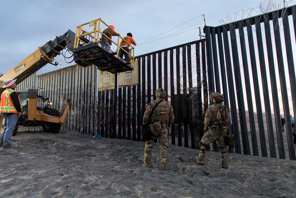 U.S. Border Patrol stands watch during border fence reinforcement