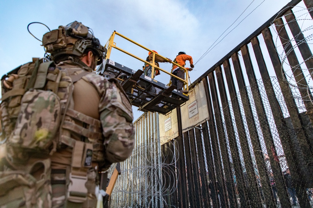 U.S. Border Patrol stands watch during border fence reinforcement