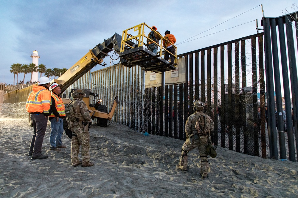 U.S. Border Patrol stands watch during border fence reinforcement