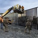 U.S. Border Patrol stands watch during border fence reinforcement