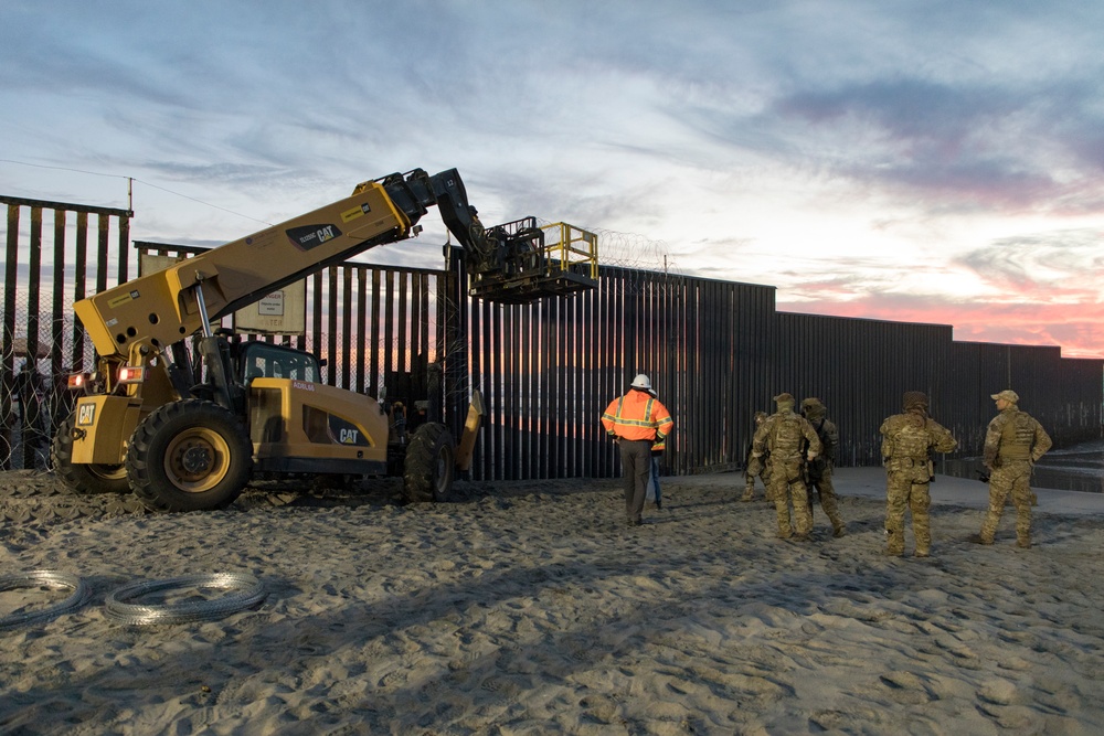 U.S. Border Patrol stands watch during border fence reinforcement