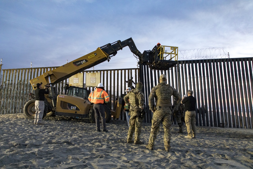 U.S. Border Patrol stands watch during border fence reinforcement