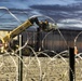 U.S. Border Patrol stands watch during border fence reinforcement