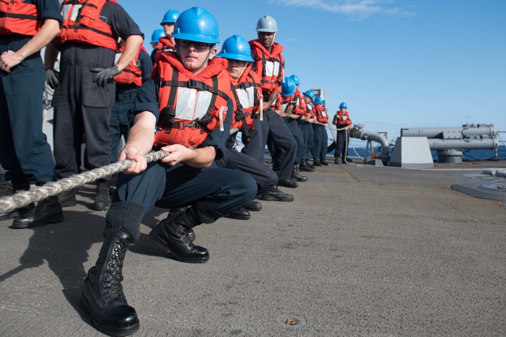 Sonar Technician (Surface) Seaman Apprentice Troy Johnson handles a line aboard USS Chung-Hoon (DDG 93) during a replenishment-at-sea.