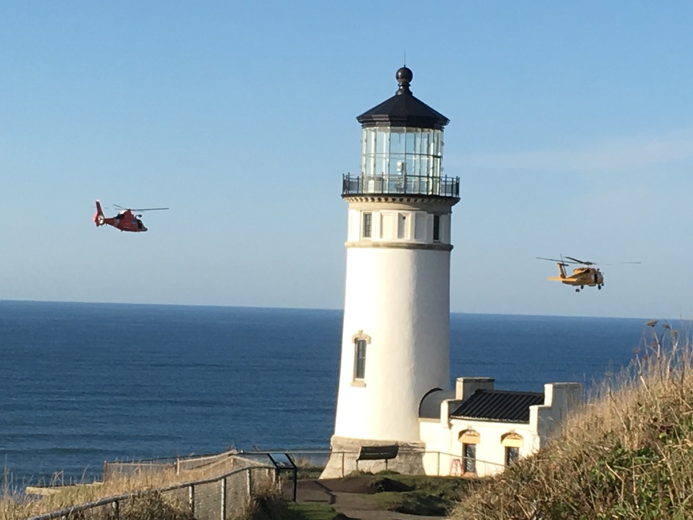 Coast Guard helicopters fly past North Head Lighthouse