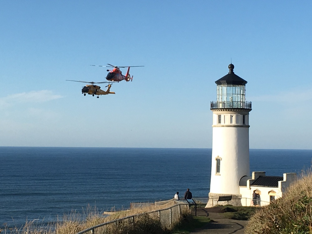 Coast Guard helicopters fly past North Head Lighthouse