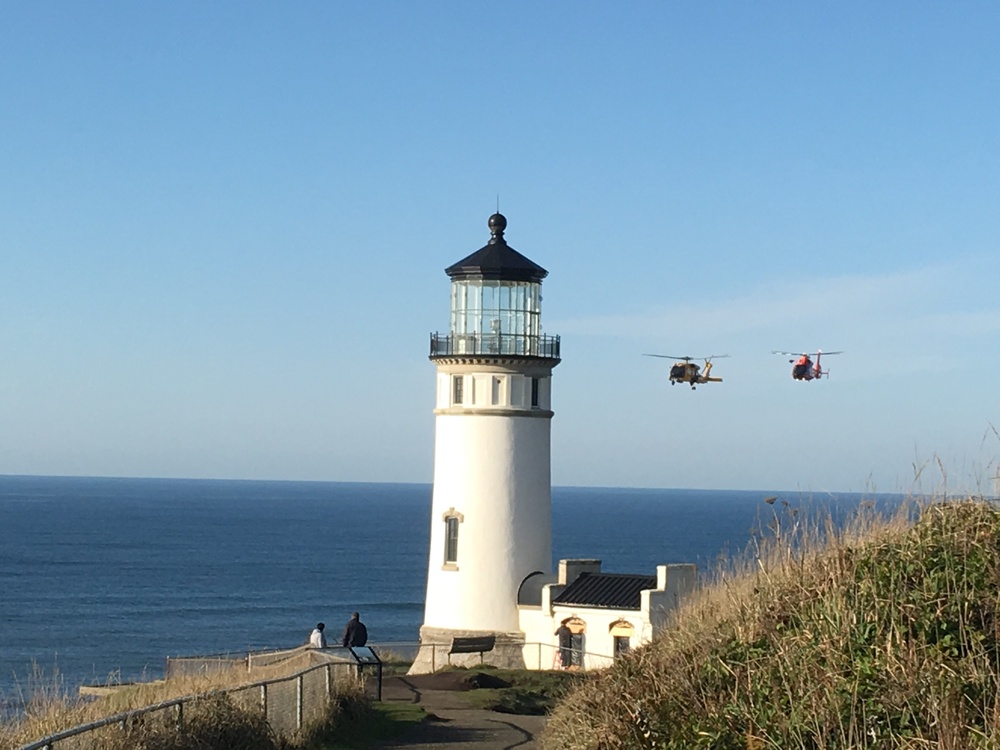 Coast Guard helicopters fly past North Head Lighthouse