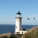 Coast Guard helicopters fly past North Head Lighthouse