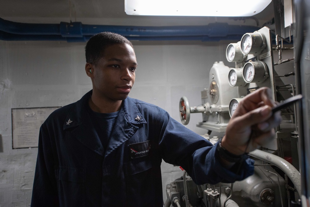 Electrician’s Mate 3rd Class Jonathan West monitors equipment while standing watch as a port steering electrician in aft steering aboard USS John C. Stennis (CVN 74).