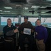 Airman Ernest Odeh poses for a photograph as the Sailor of the Day with Capt. Randy Peck, right, commanding officer of USS John C. Stennis (CVN 74), and Command Master Chief Benjamin Rushing.