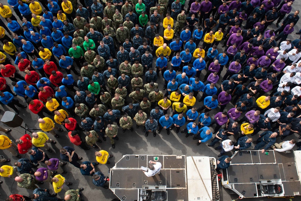 Cmdr. Pavao Huldisch, head of the Air department aboard USS John C. Stennis (CVN 74), addresses Sailors on the flight deck during a department quarters.