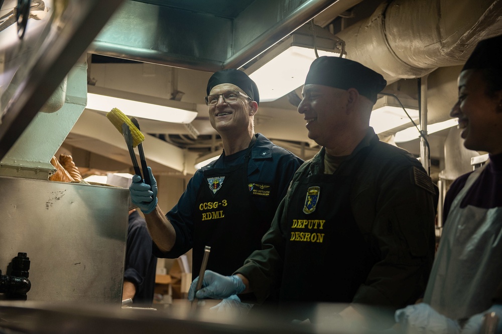 Rear Adm. Michael Wettlaufer, commander, Carrier Strike Group (CSG) 3, serves Thanksgiving dinner in the forward galley aboard USS John C. Stennis (CVN 74).