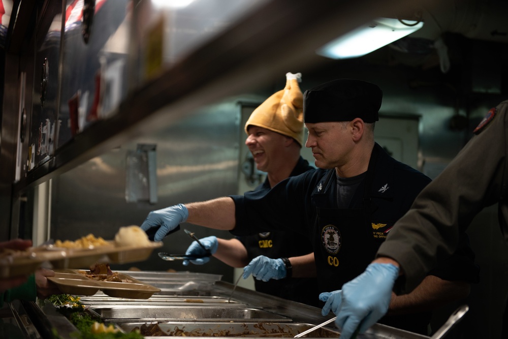 Capt. Randy Peck, commanding officer of USS John C. Stennis (CVN 74), serves Thanksgiving dinner in the aft galley.