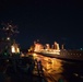 Sailors handle a line aboard USS Chung-Hoon (DDG 93), left, during a replenishment-at-sea.