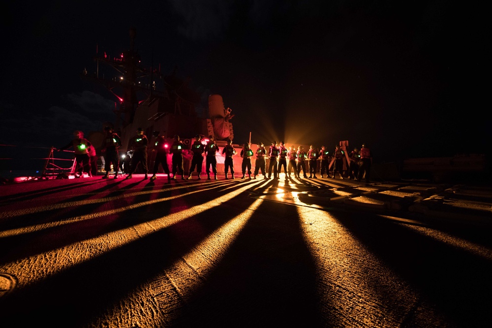 Sailors handle a line aboard USS Chung-Hoon (DDG 93) during a replenishment-at-sea.