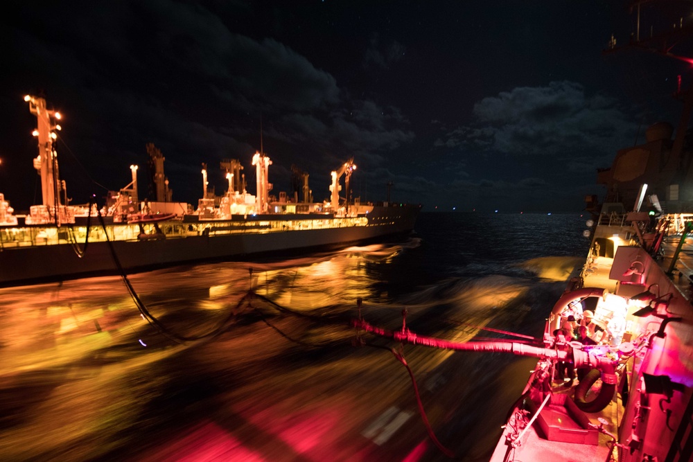 Sailors monitor a refueling station aboard USS Chung-Hoon (DDG 93), right, during a replenishment-at-sea.