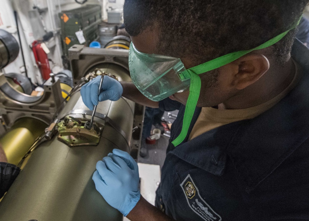 Sonar Technician (Surface) 2nd Class Jeffery Hudson greases the pawl lever wires of an MK 46 torpedo aboard USS Mobile Bay (CG 53).