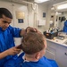 Ship's Serviceman 3rd Class Banod Panday gives a Sailor a haircut aboard USS Mobile Bay (CG 53).