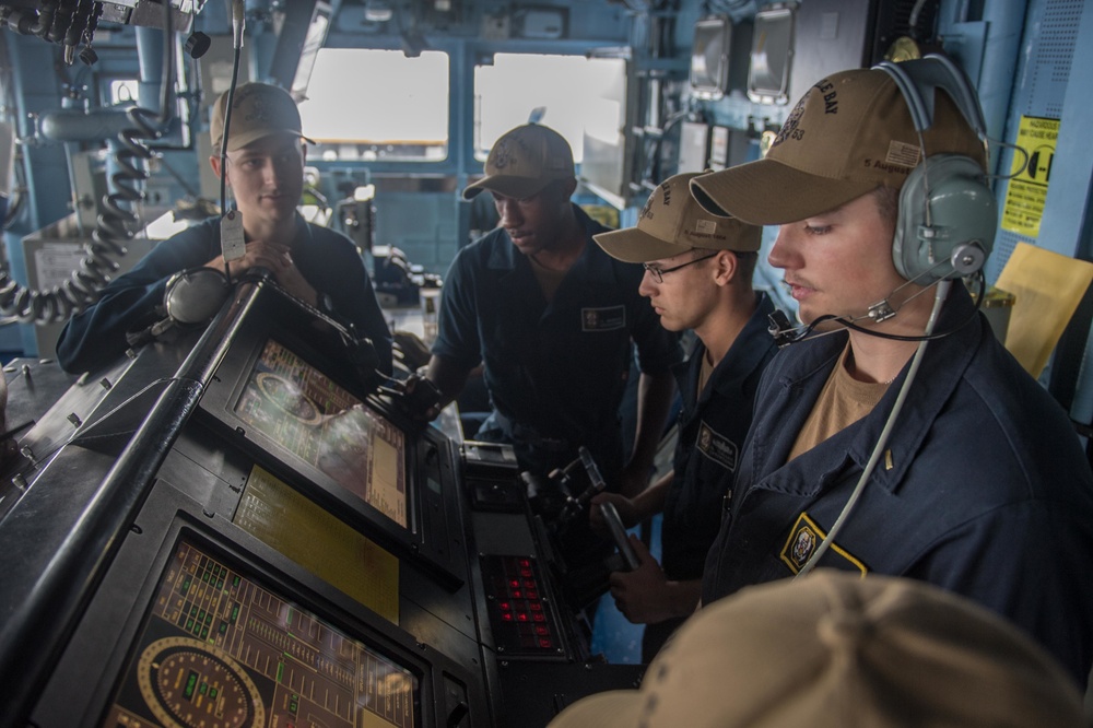 Sailors aboard USS Mobile Bay (CG 53) maneuver the ship from the pilot house during a replenishment-at-sea.