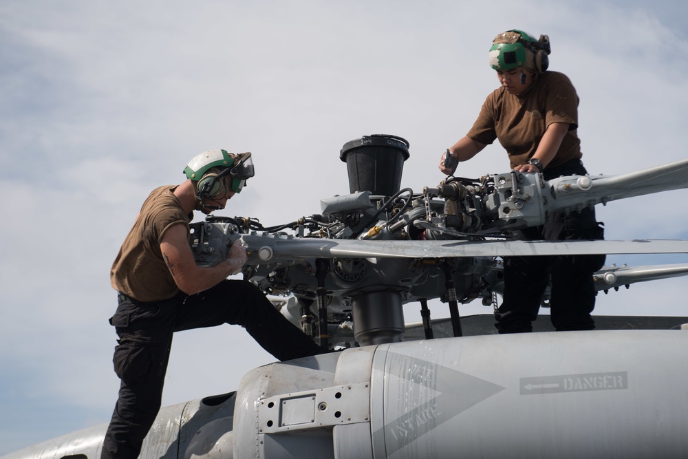 Aviation Electronics Technician 3rd Class Alton Laussade, left, and Aviation Machinist’s Mate Airman Remely Culasclean the main rotor pylon of an MH-60R Sea Hawk, with Helicopter Maritime Strike Squadron (HSM) 37, aboard USS Chung-Hoon (DDG 93).