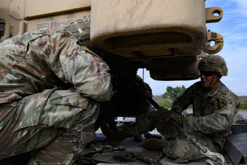 Soldiers load equipment onto trailer