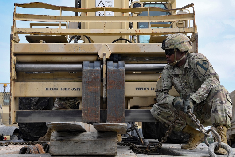 Soldiers load equipment onto trailer