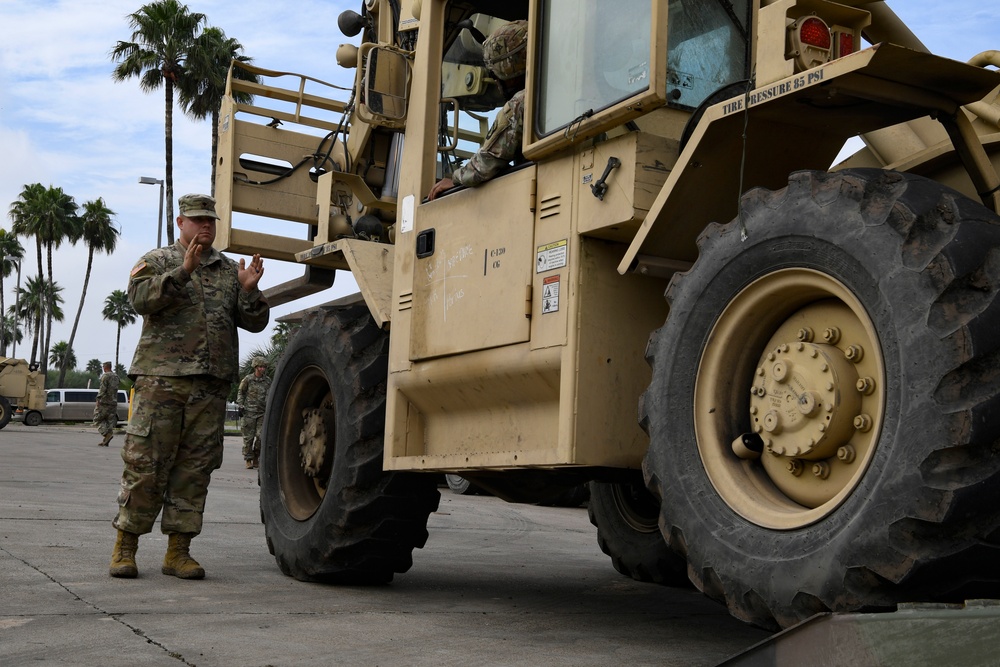 Soldiers load equipment onto trailer