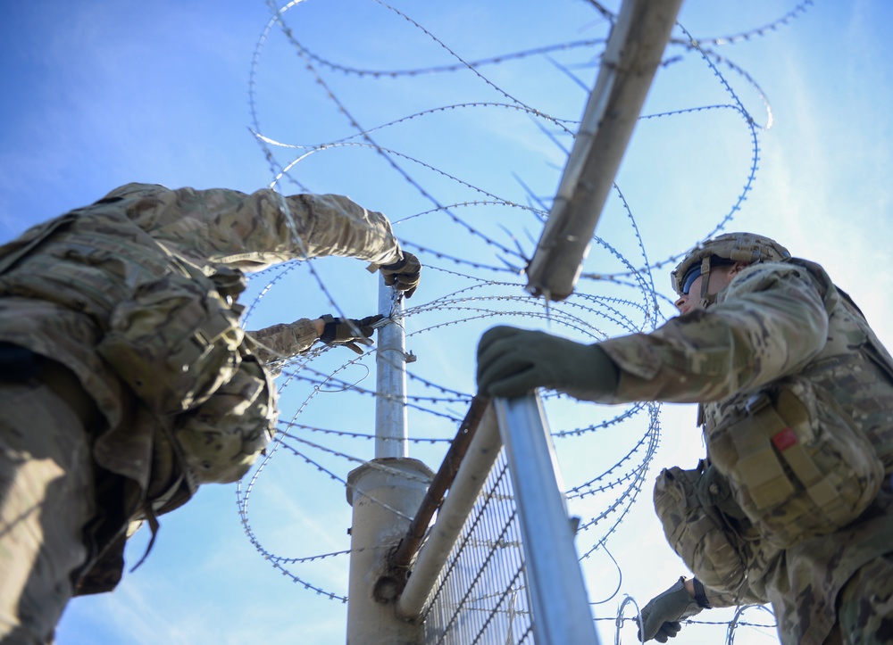 Soldiers Lay Concertina Wire Along Veterans International Bridge