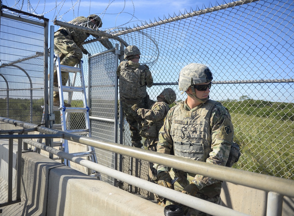 Soldiers Lay Concertina Wire Along Veterans International Bridge