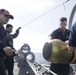 Sailors maneuver a MK 46 Mod 5A(S) torpedo while loading the launch system during maintenance aboard USS Spruance (DDG 111).