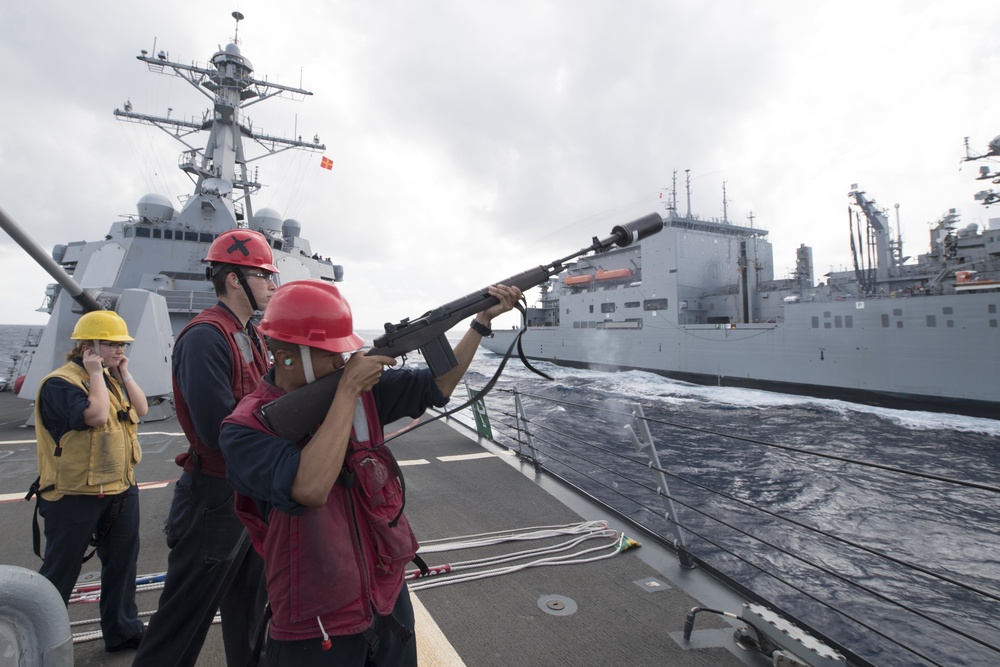 Gunner’s Mate Seaman Clay Jocson fires a shot line from USS Spruance (DDG 111) during a replenishment-at-sea.
