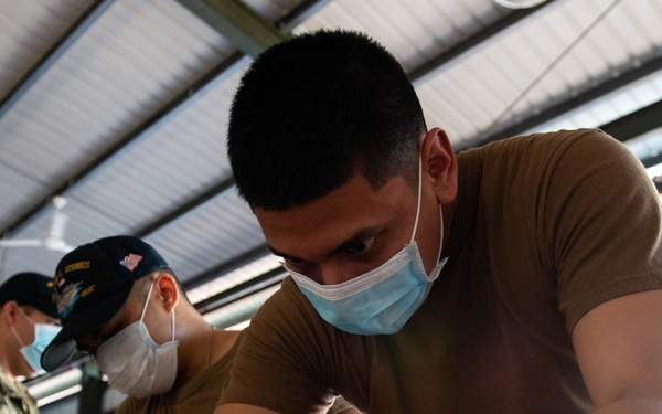 Yeoman Seaman Adrian Gonzalez, from Merced, California, sorts donated toys, clothes, and electronics at the Tanglin Salvation Army donation center in Singapore during a community outreach event.