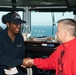 Seaman Recruit Dominique E. Henderson receives a challenge coin from Capt. Randy Peck, commanding officer of USS John C. Stennis (CVN 74), for her selection as the Sailor of the Day.