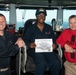 Seaman Recruit Dominique E. Henderson poses for a photograph as the Sailor of the Day with Capt. Randy Peck, right, commanding officer of USS John C. Stennis (CVN 74), and Command Master Chief Benjamin Rushing.