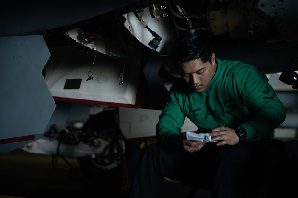 Aviation Machinist’s Mate 3rd Class Miguel Montealegre conducts maintenance on an F/A-18E Super Hornet, with Strike Fighter Squadron (VFA) 151, in the hangar bay aboard USS John C. Stennis (CVN 74).