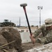 A Soldier Hammers a Post for Ramp Construction
