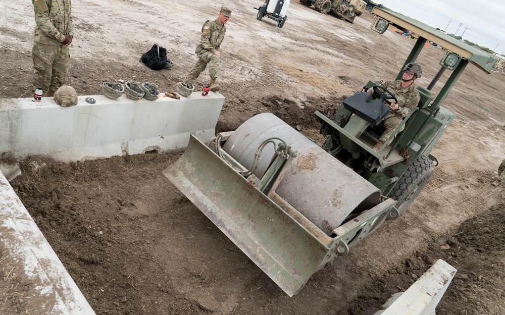 A Soldier Smooths the Dirt Around a Constructed Loading Ramp