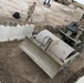 A Soldier Smooths the Dirt Around a Constructed Loading Ramp