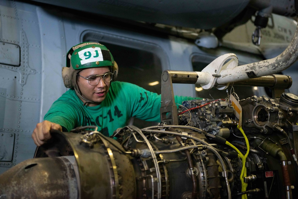 Aviation Machinist’s Mate 3rd Class Ruben Lopez, from Pasadena, Texas, removes an engine from an MH-60S Knight Hawk, with Helicopter Sea Combat Squadron (HSC) 14, in the hangar bay aboard the Nimitz-class aircraft carrier USS John C. Stennis (CVN 74).