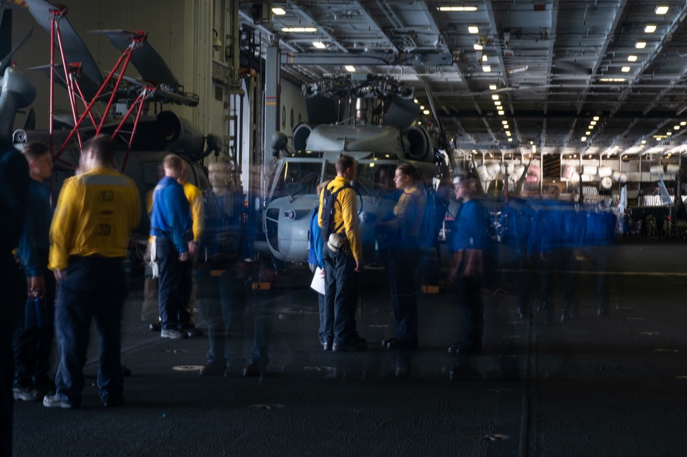 Sailors transit the hangar bay aboard the Nimitz-class aircraft carrier USS John C. Stennis (CVN 74).