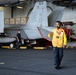 Aviation Boatswains Mate (Handling) 3rd Class Nahom Abebe, from Denver, directs an MH-60S Knight Hawk, with Helicopter Sea Combat Squadron (HSC) 14, into the hangar bay aboard the Nimitz-class aircraft carrier USS John C. Stennis (CVN 74).