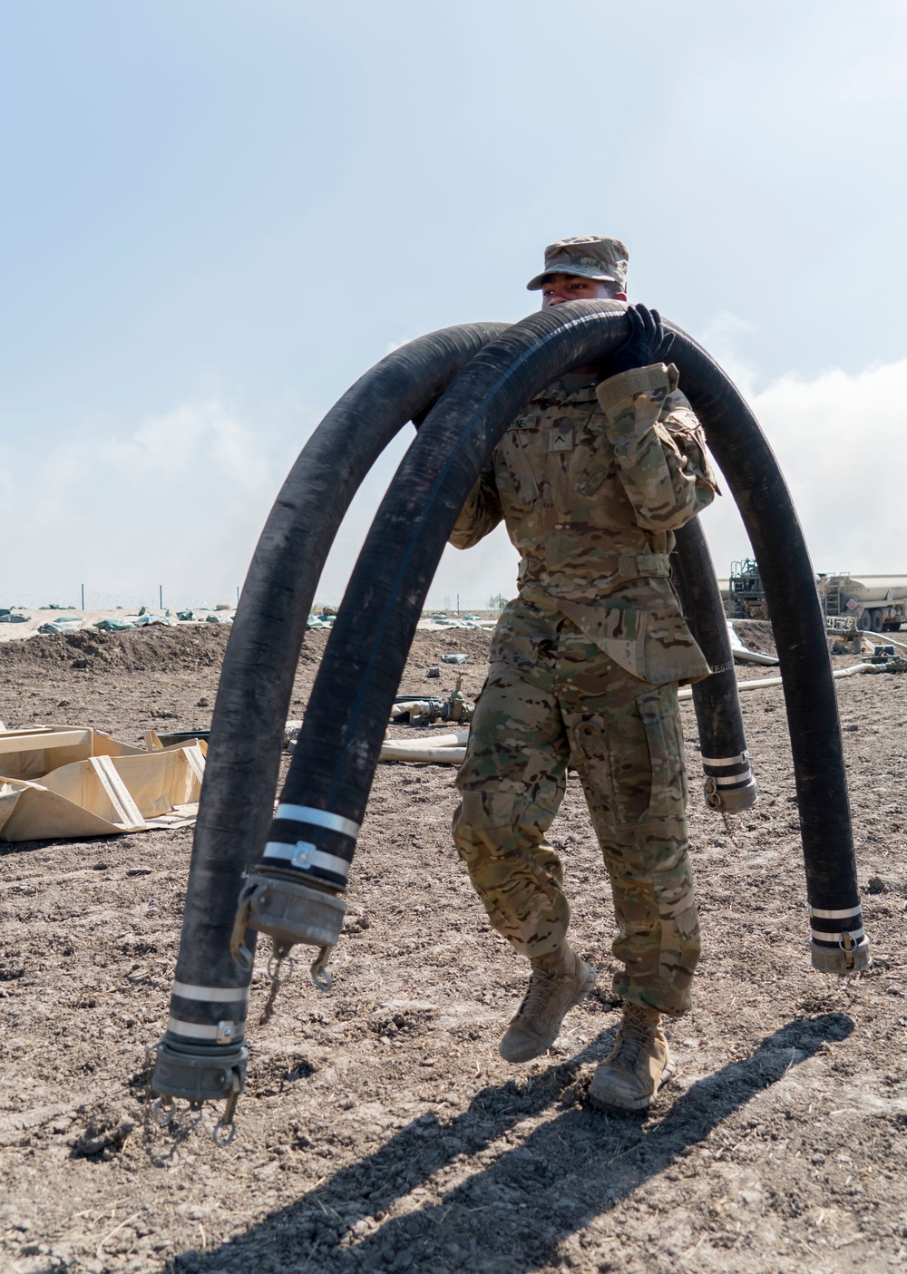 A Soldier Hauls Fuel Lines for Storage